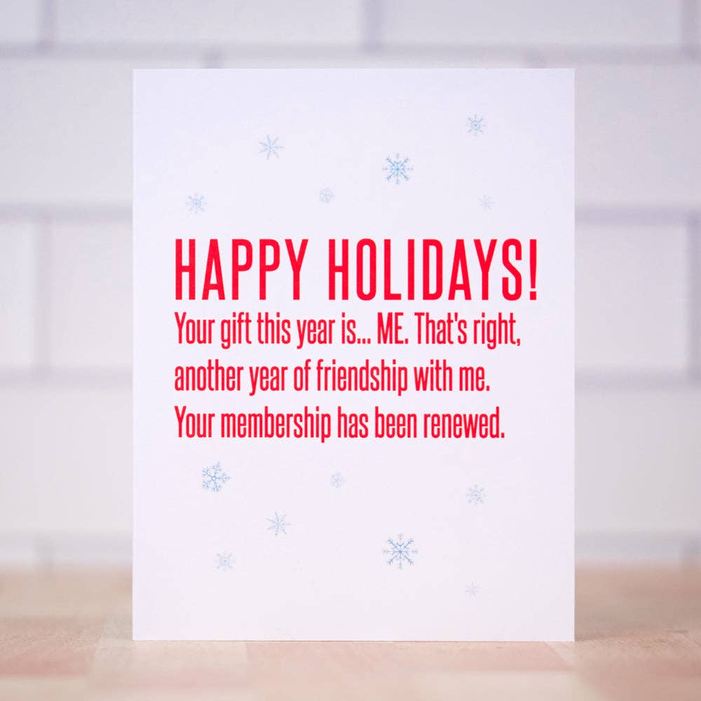 A white greeting card with red text reading 'HAPPY HOLIDAYS! Your gift this year is.