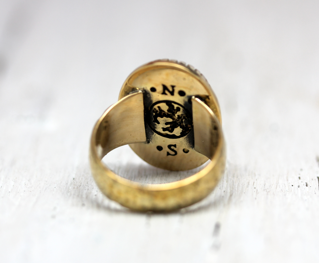 Slver ring with engraved design on a light background