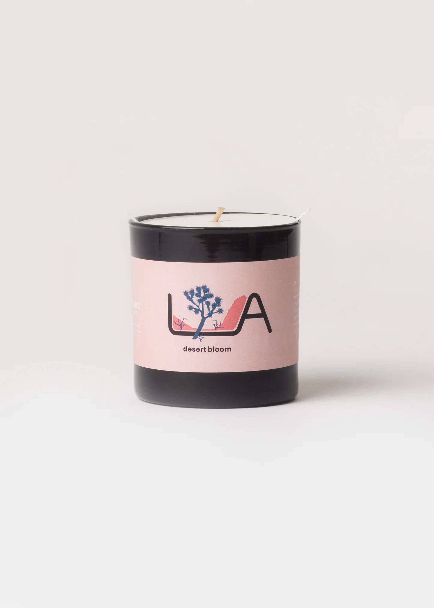 Candle with a pink label featuring a logo on a white background