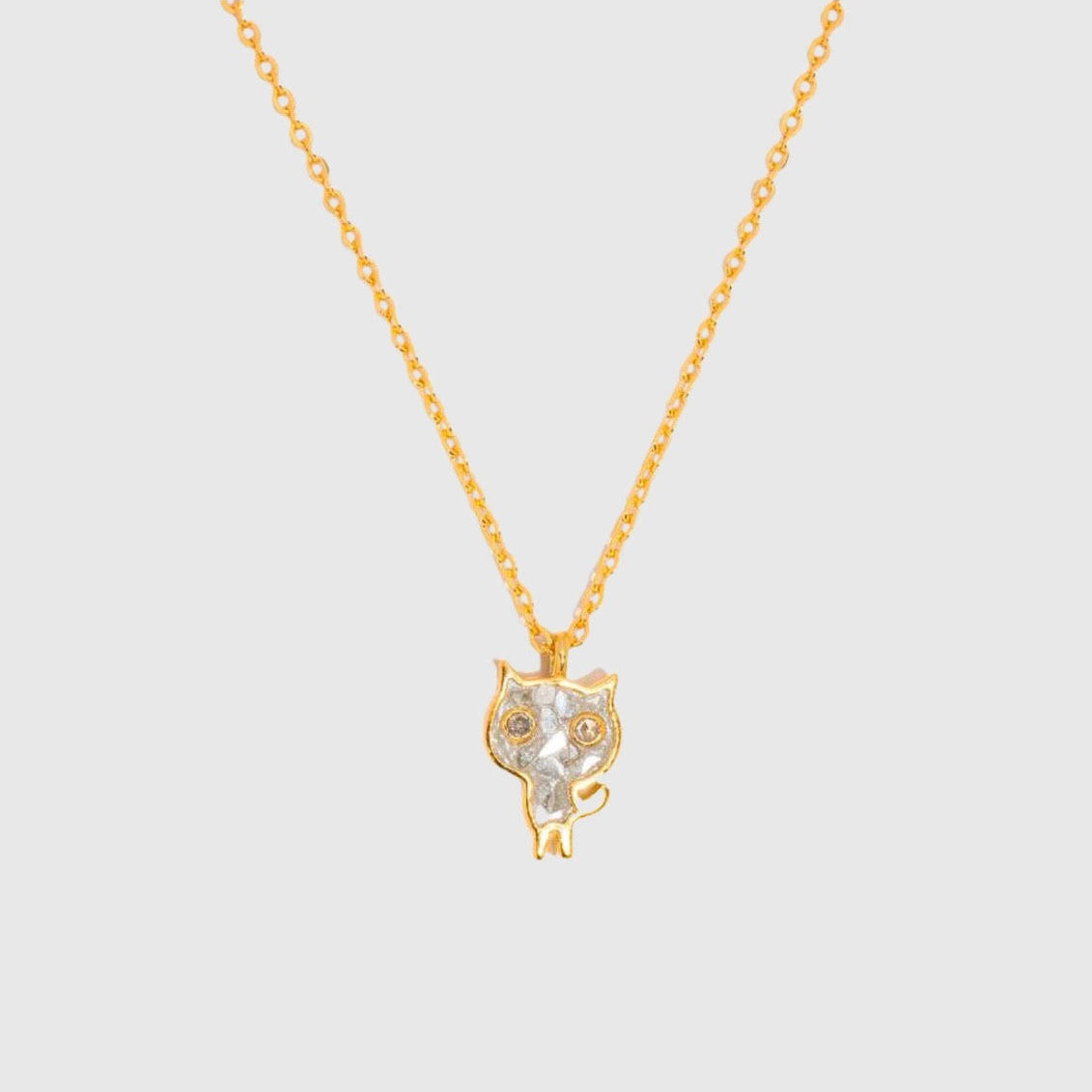 Gold cat-shaped pendant necklace on a light gray background