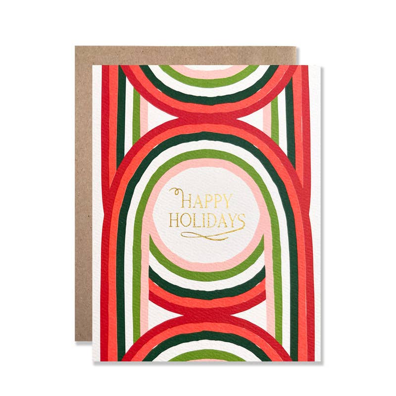A holiday greeting card with a kraft envelope, featuring a retro pattern of red, green, and pink concentric arches with gold foil text reading 'Happy Holidays' in the center.