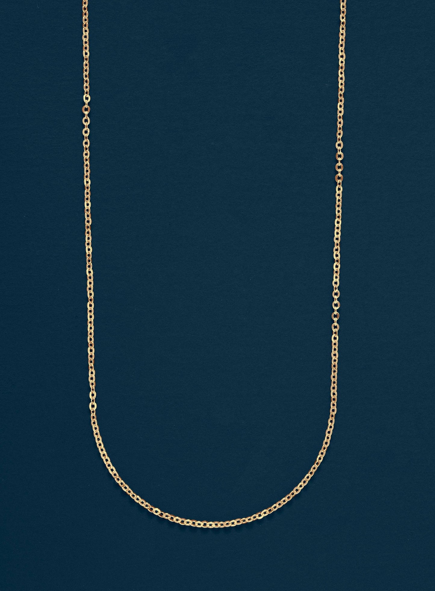Gold chain necklace on a dark blue background