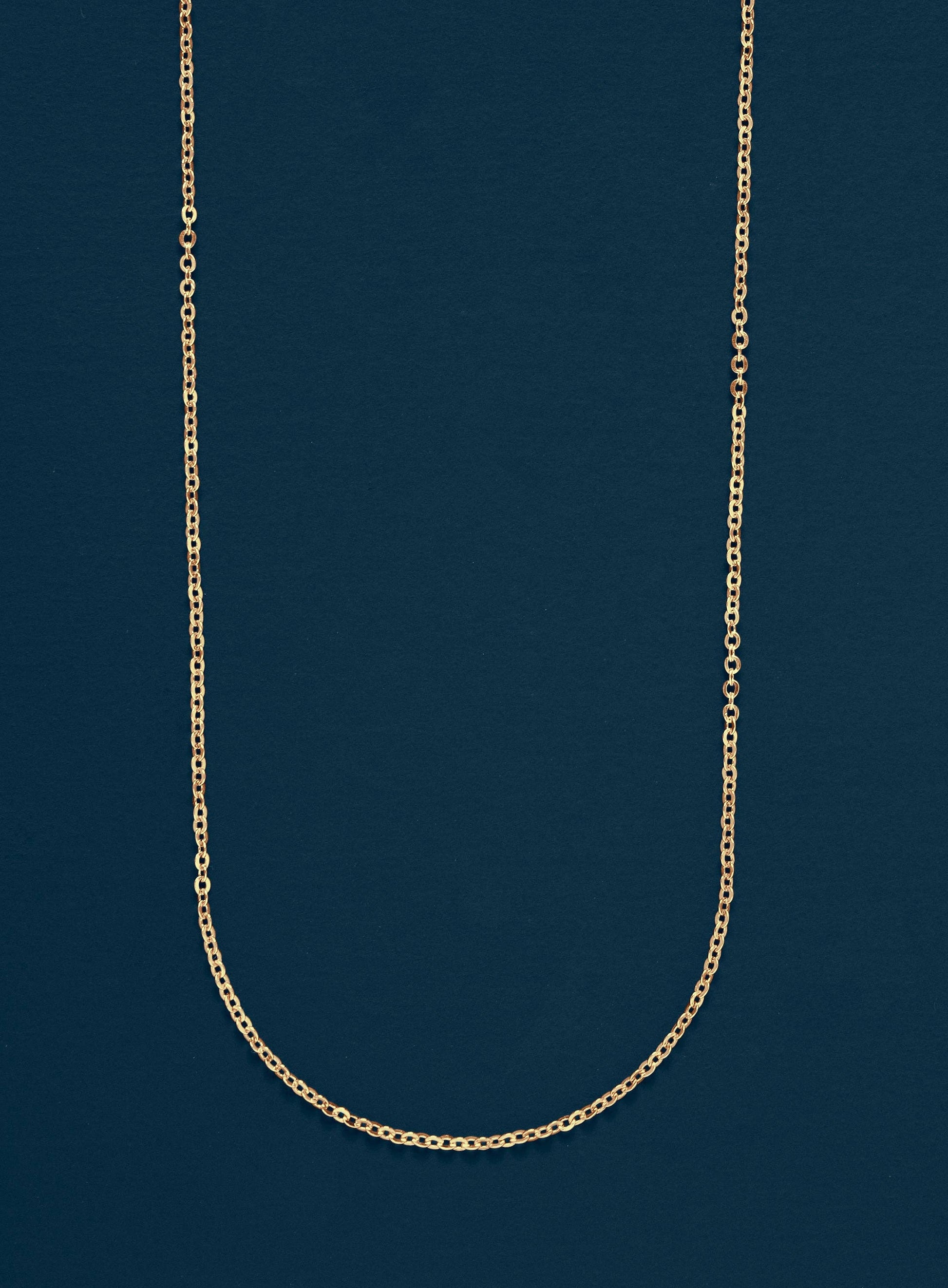 Gold chain necklace on a dark blue background