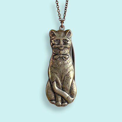Metallic cat-shaped pendant a chain on a light gray background