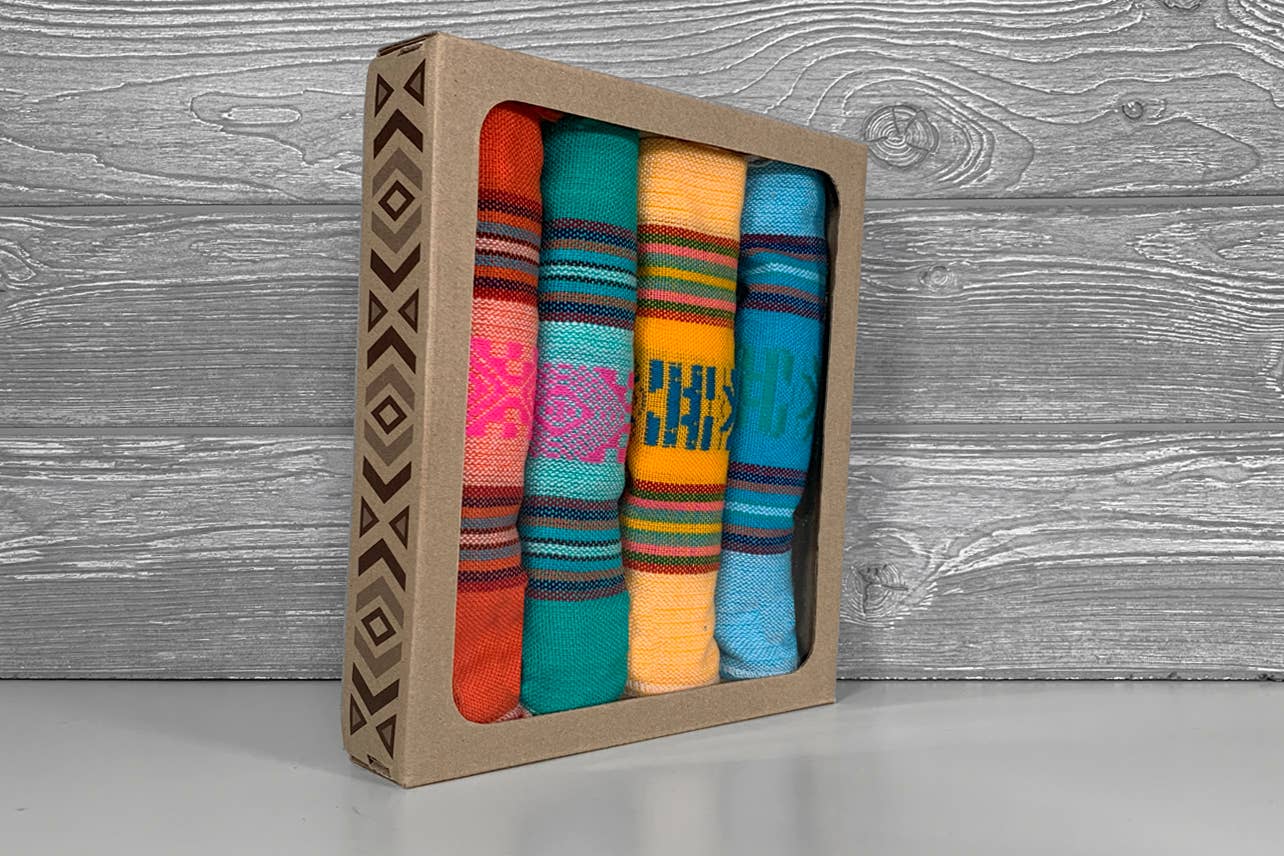 Set of colorful woven strips in a cardboard box on a wooden surface