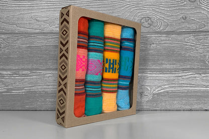 Set of colorful woven strips in a cardboard box on a wooden surface
