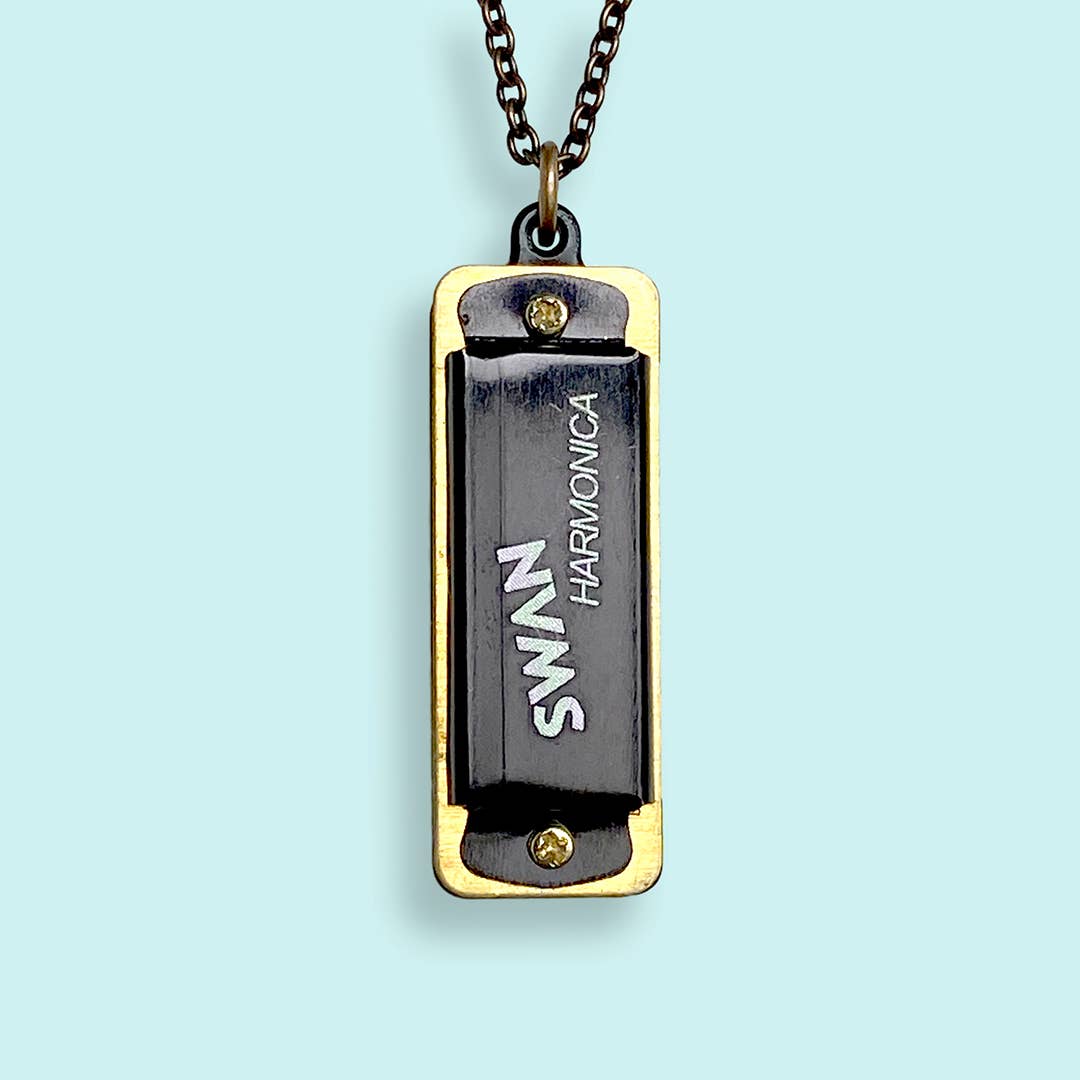 Harmonica-shaped pendant with 'Swan' branding on a light blue background