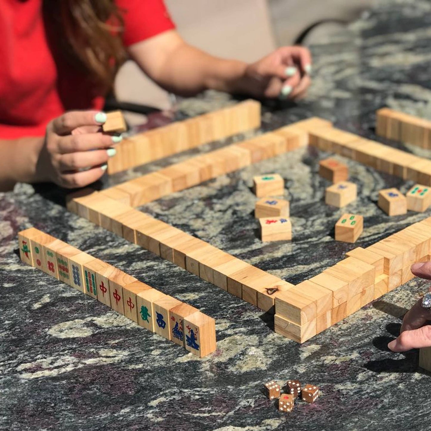 Wooden block game being played on a marble surface with two players.