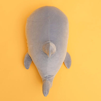 Gray plush shark toy on a yellow background