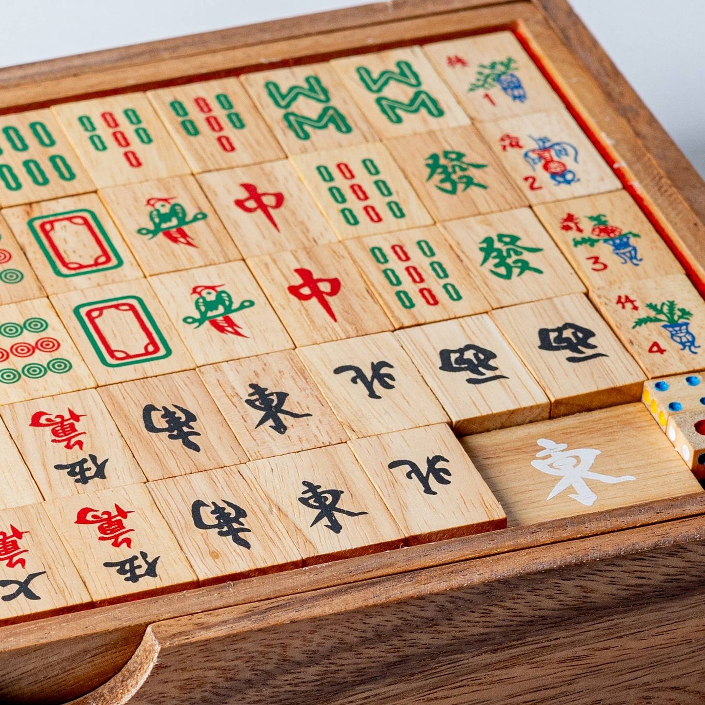 Wooden Mahjong game set with tiles featuring Chinese characters and symbols.