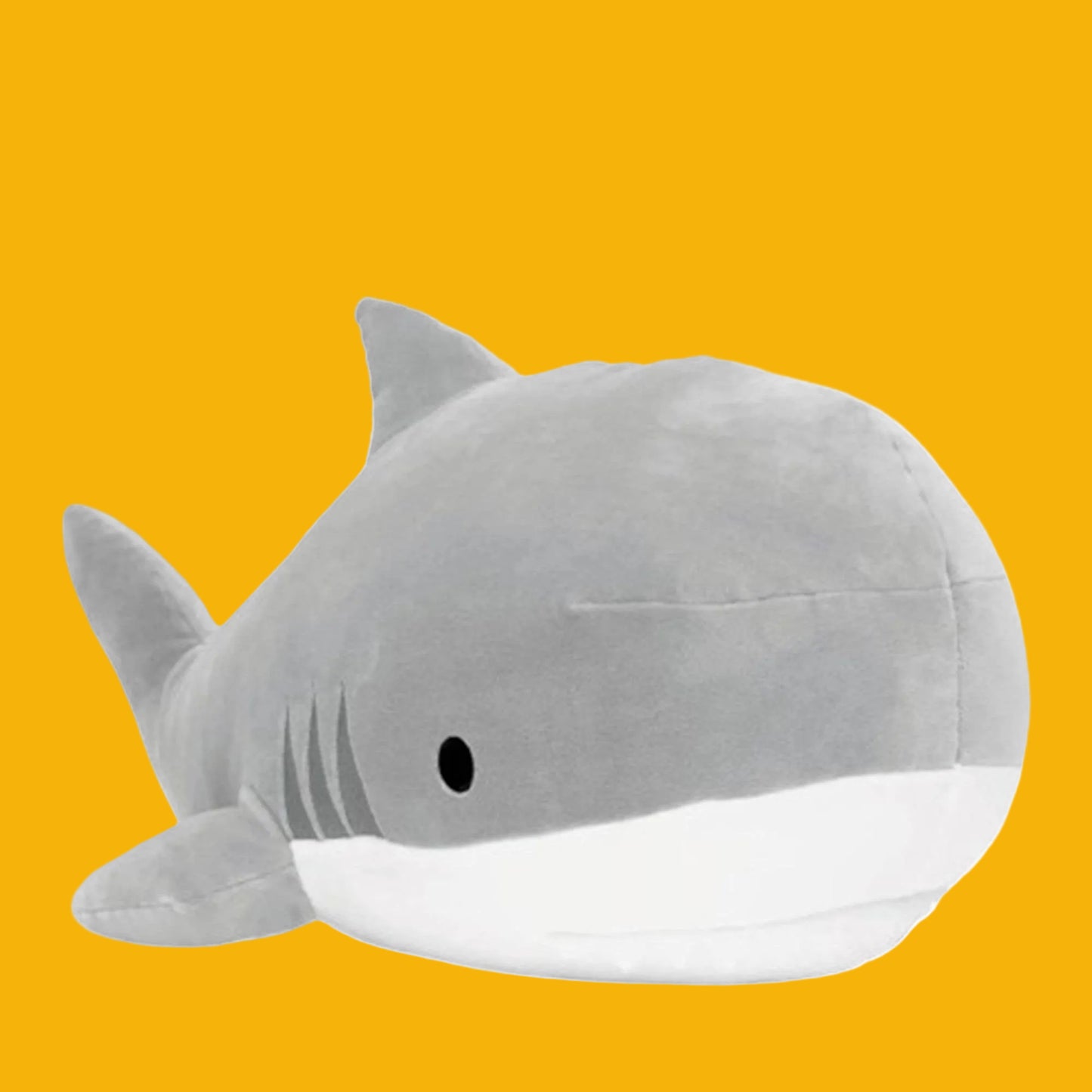 Gray shark plush toy on a yellow background