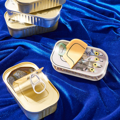 Metallic containers with fishing lures on a blue fabric background