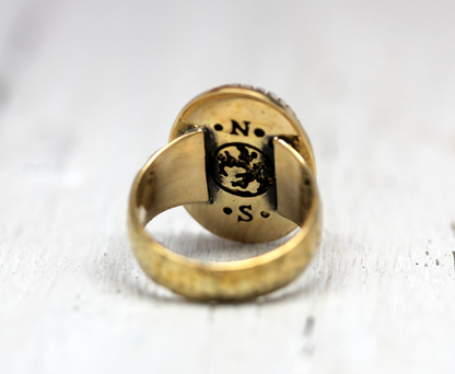Slver ring with engraved design on a light background