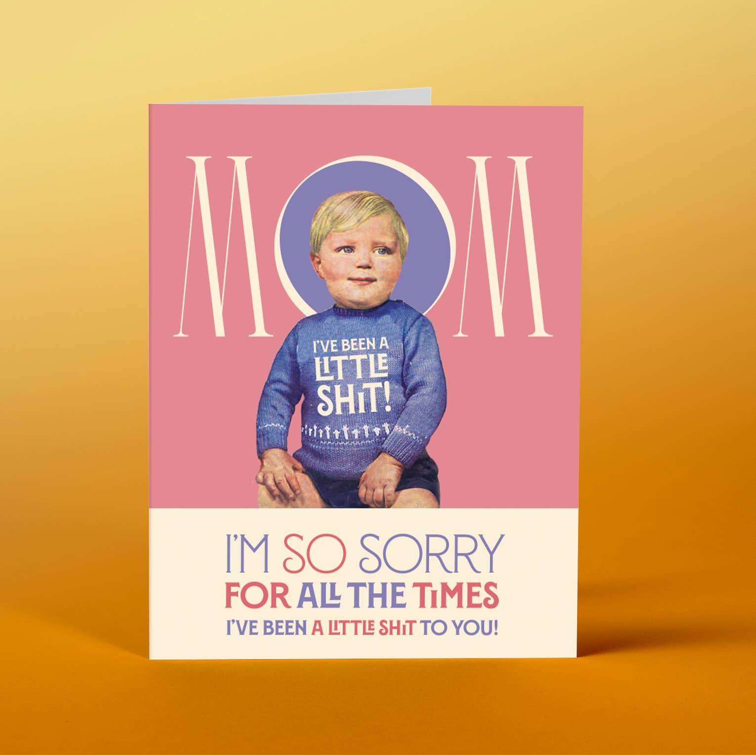 Card with a child wearing a sweater with text, on a pink background with 'Mom' text.