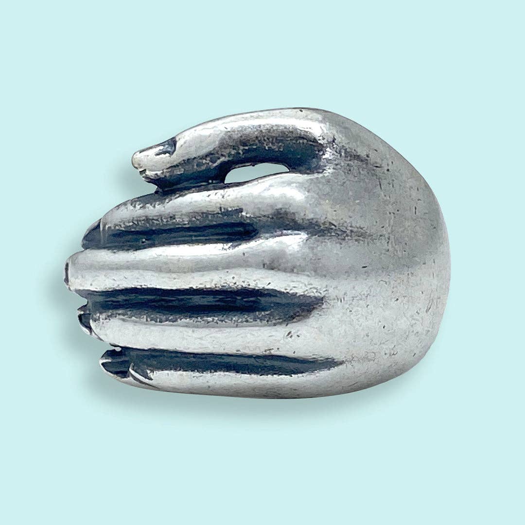 Metallic claw-like object on a light blue background
