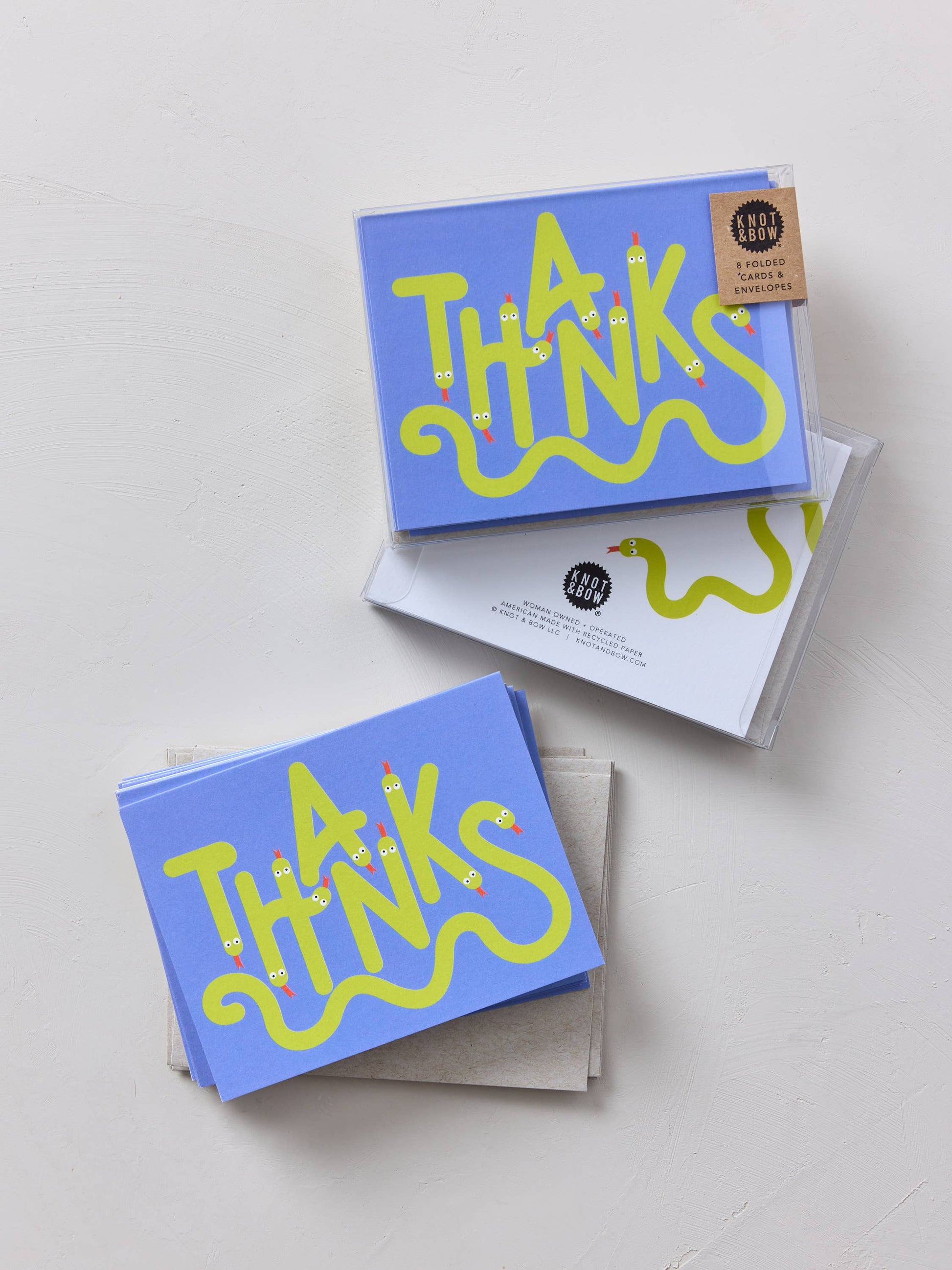 Stack of blue greeting cards with yellow 'THANKS' text on a light gray background