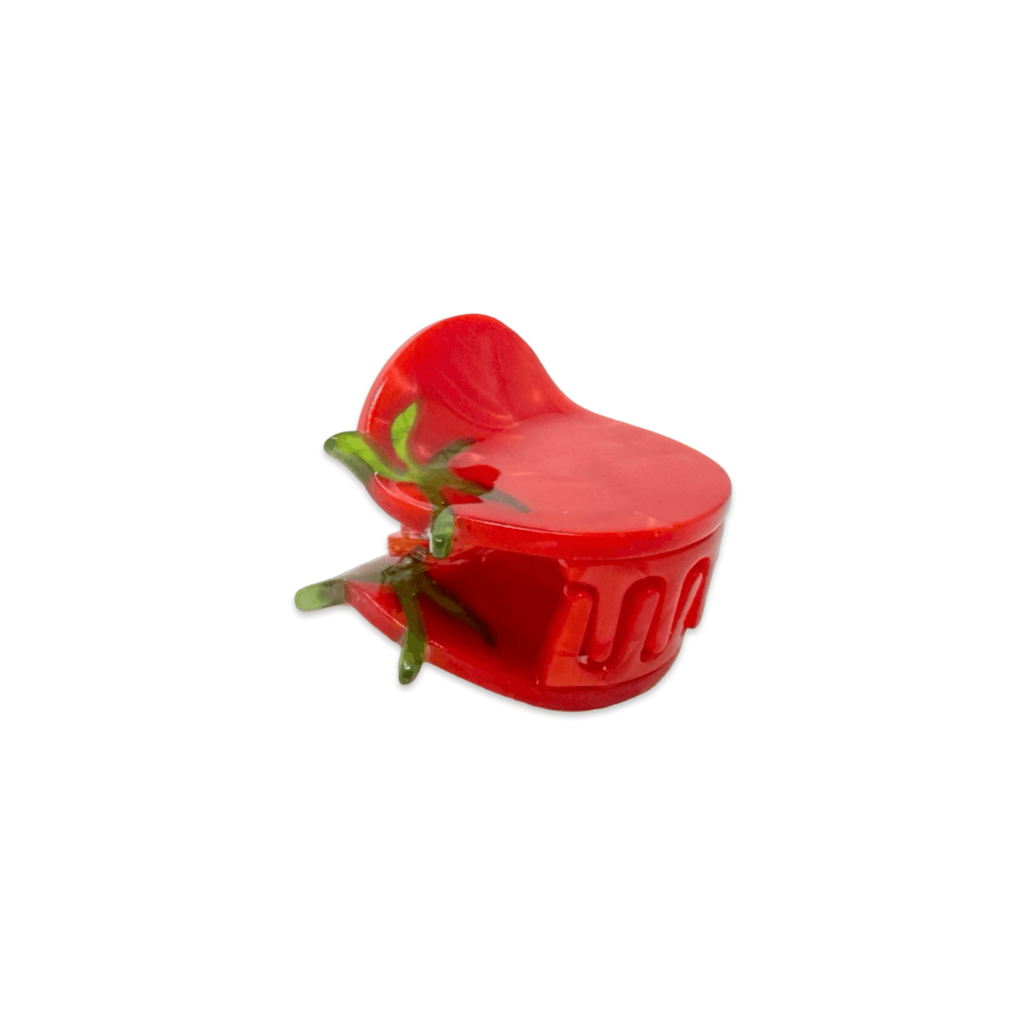 Red tomato-shaped container with green leaves on a white background
