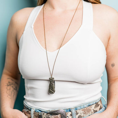 image of person wearing a Metallic cat-shaped knife with a chain 