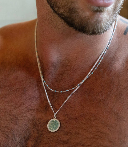 Man wearing a Saint Christopher medal necklace.