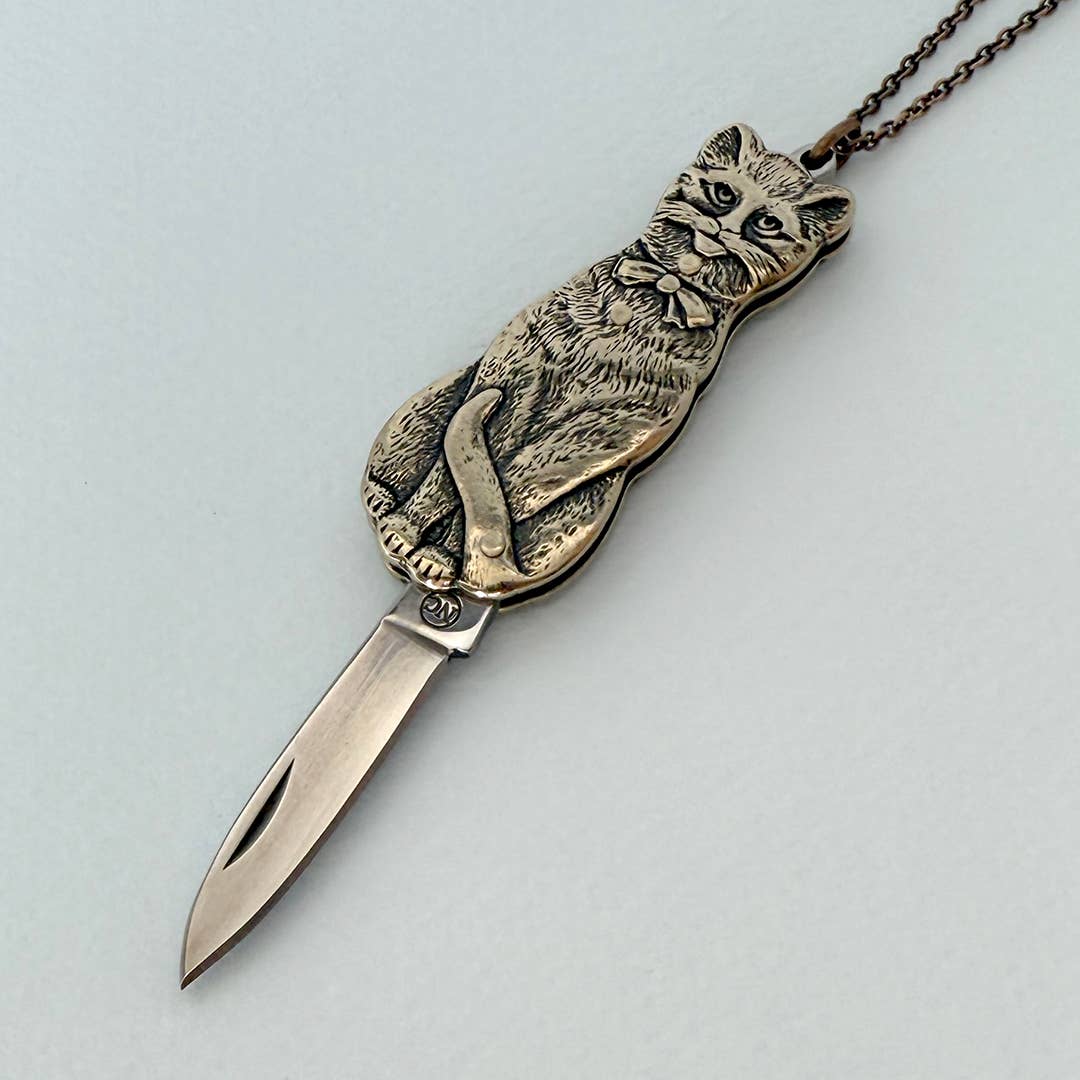 Metallic cat-shaped knife with a chain on a light gray background