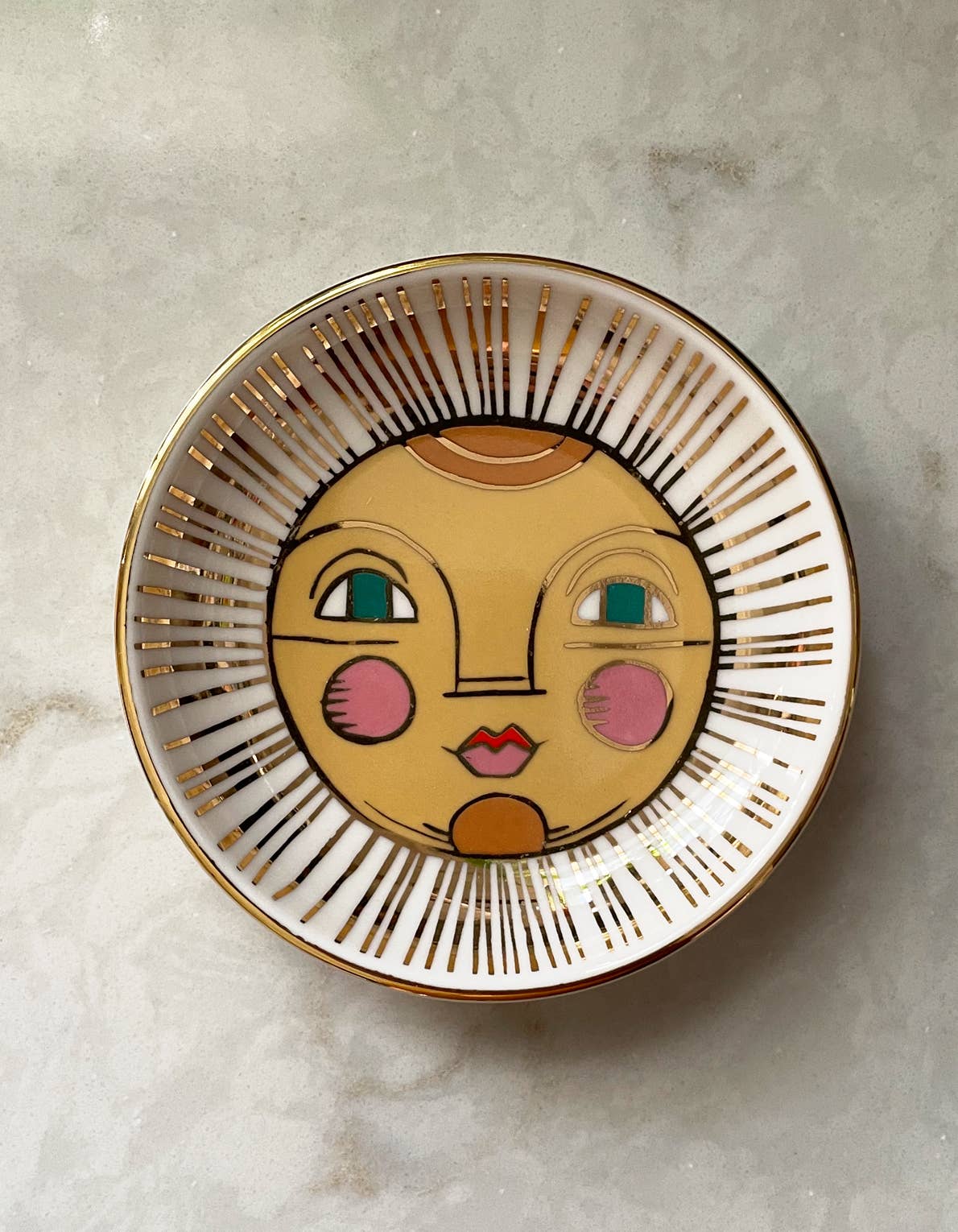 Decorative plate with a face design on a light gray background
