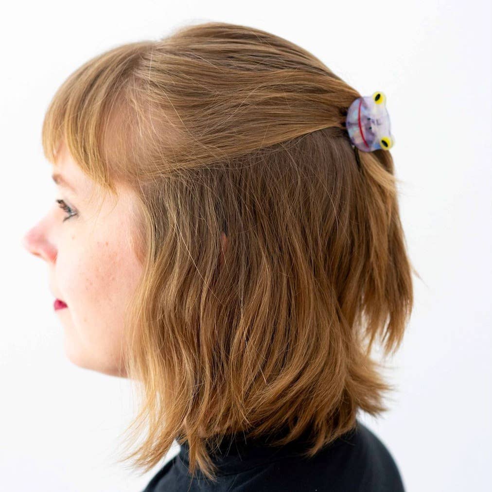 Person with a hair clip featuring a cartoon character on a white background