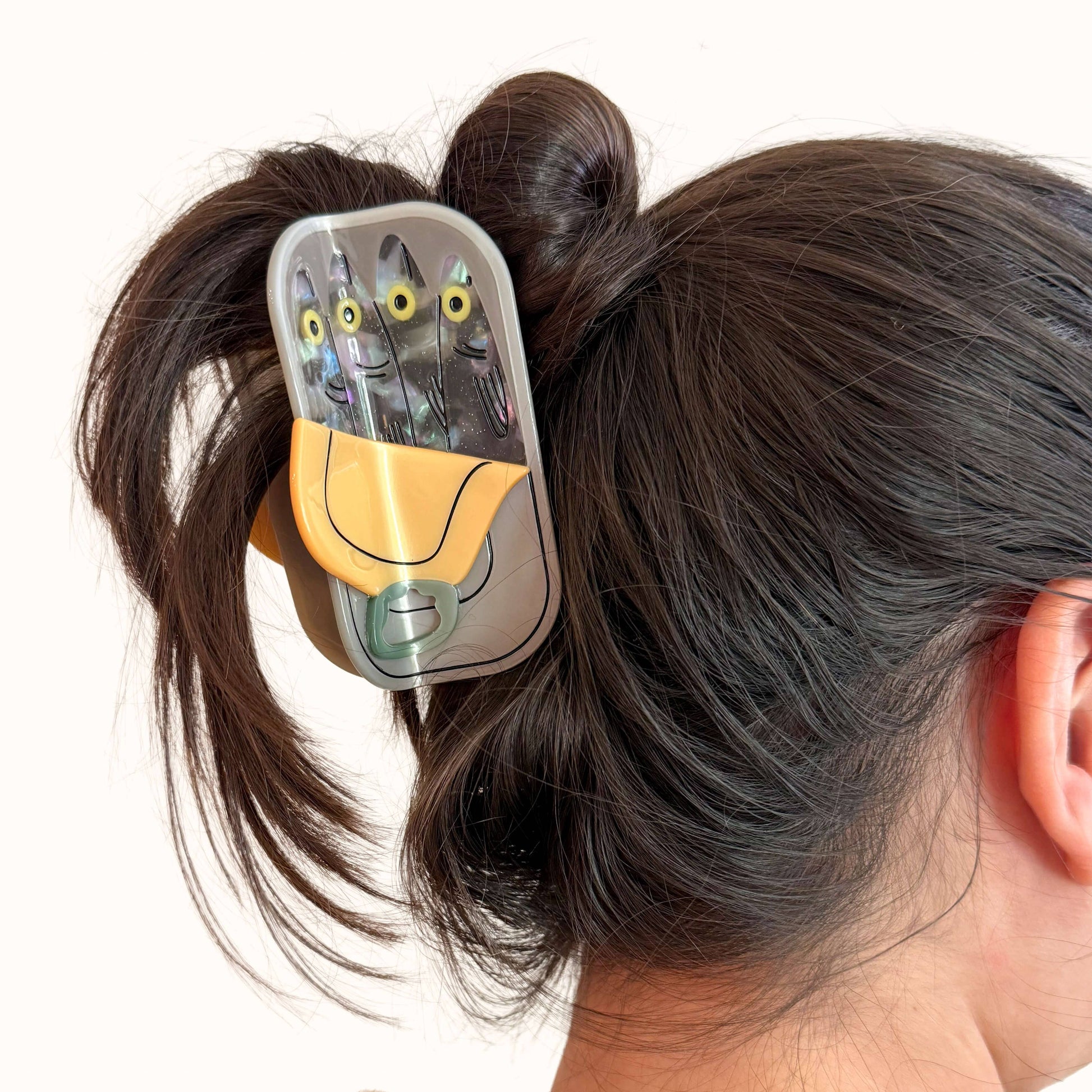 Hair clip with cartoon design in a person's hair on a white background