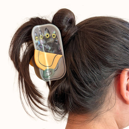 Hair clip with cartoon design in a person's hair on a white background
