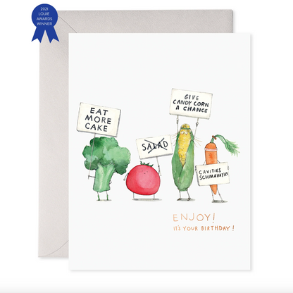 Greeting card with a cartoon illustration of vegetables including broccoli, carrot, and cucumber with signs and a cake, with the text 'Enjoy! It's your birthday!'.
