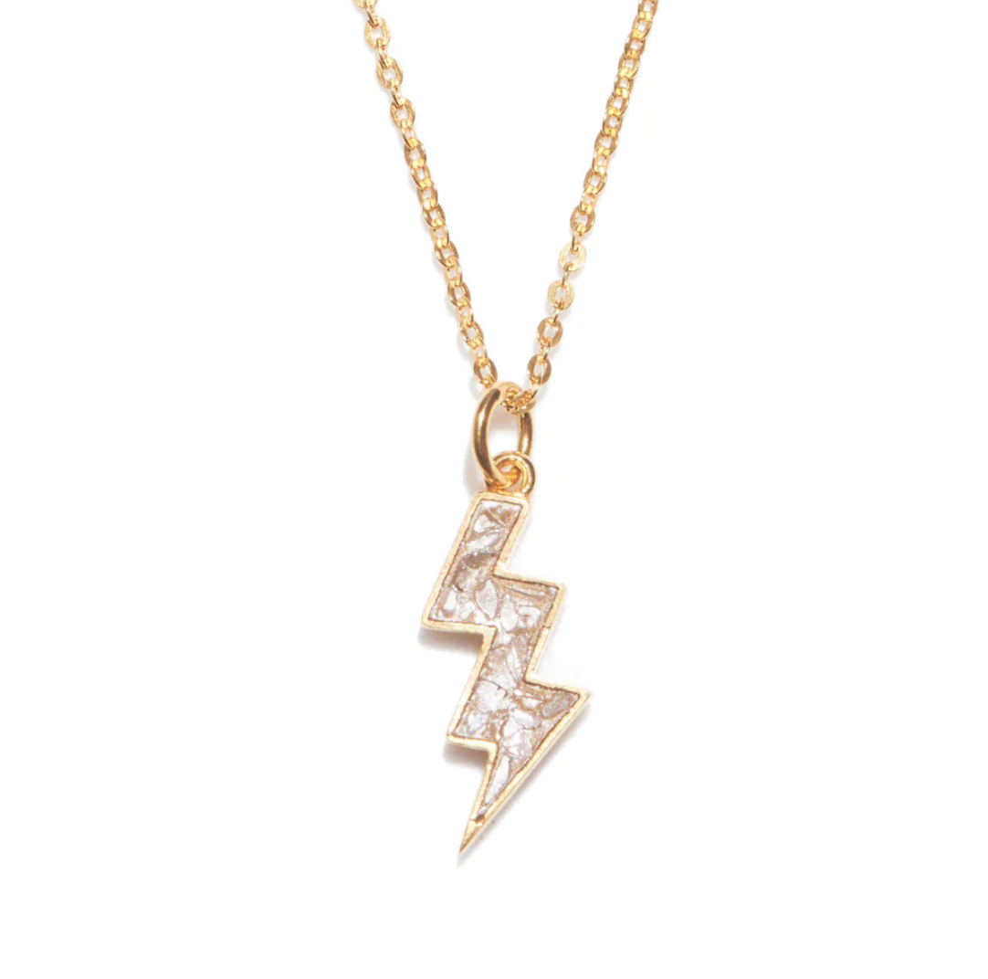A gold-tone bolt pendant necklace with a chain, featuring sliced raw uncut diamonds and pave black diamonds.