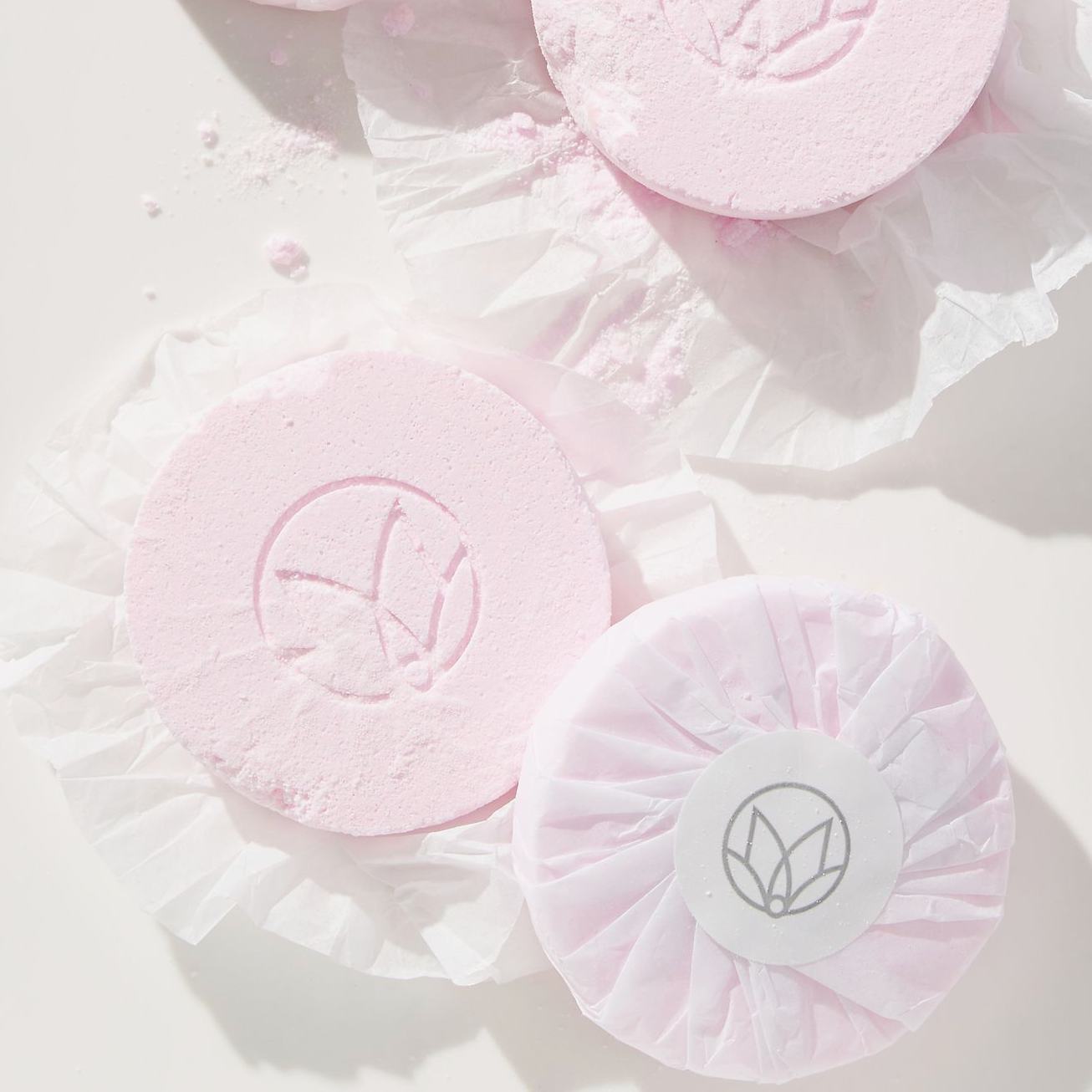 Pink bath bombs with a logo on a light background