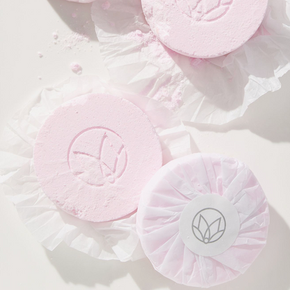 Pink bath bombs with a logo on a light background