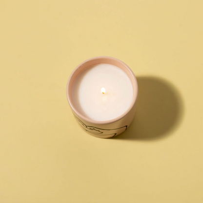 Candle in a pink container on a beige background