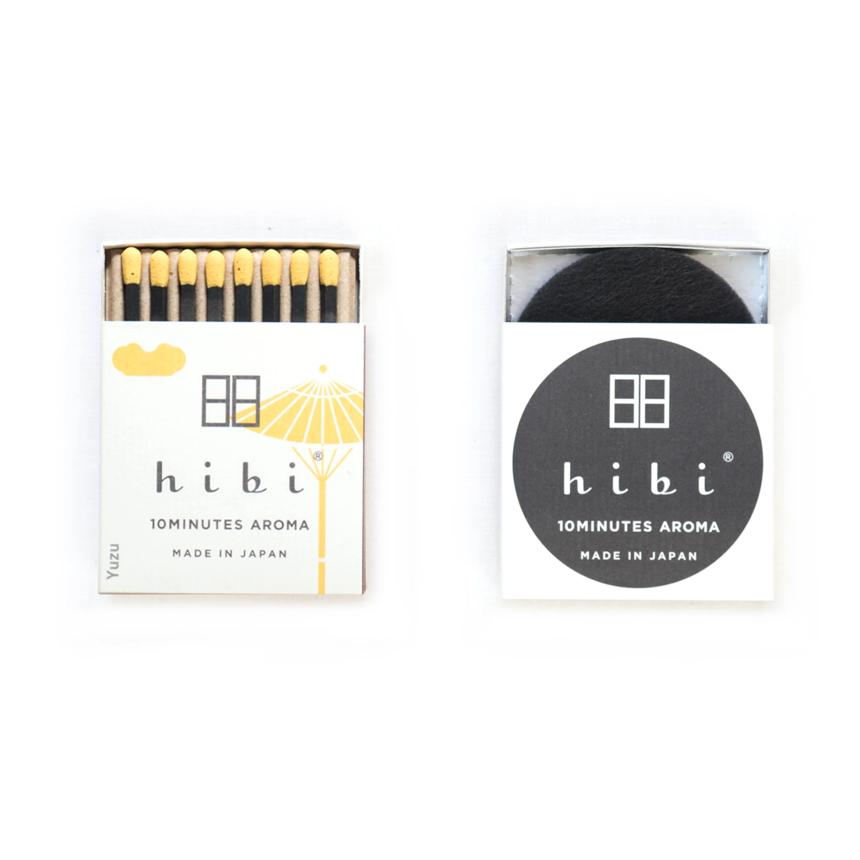 Two boxes of hibi matches, one with a white label and yellow design, the other with a black label and white design.