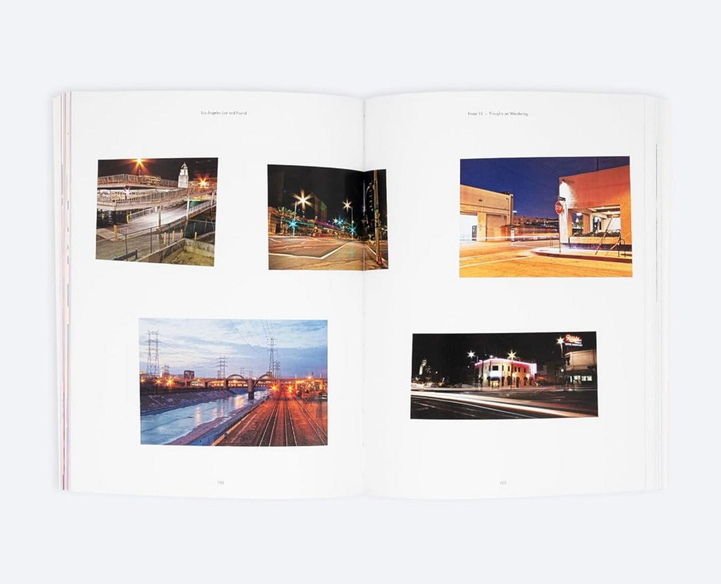 An open book or magazine spread showing five small rectangular photographs printed on white pages, photographed against a light gray background.