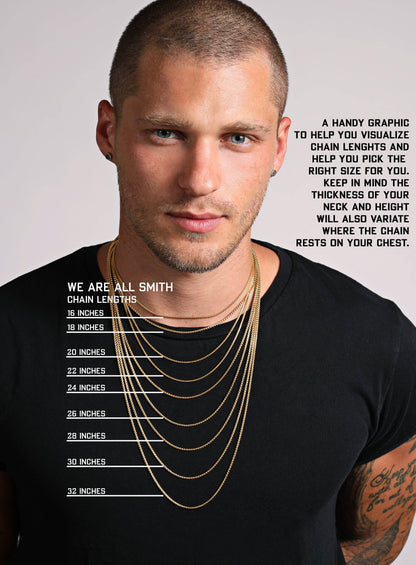 Man wearing gold chains with a chart on his black t-shirt, against a gray background.