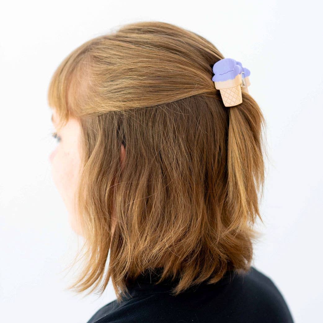 Person with a hair clip shaped like an ice cream cone on a white background