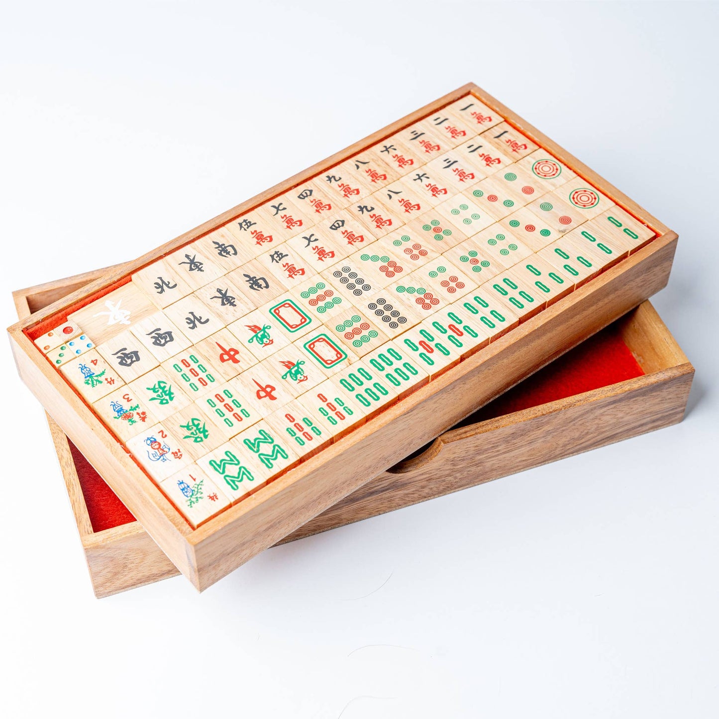 Wooden mahjong set with tiles on a white background