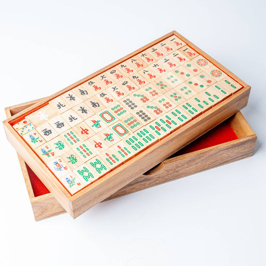 Wooden mahjong set with tiles on a white background