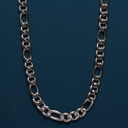 A silver-toned metal chain necklace with elongated oval links, arranged in a U-shape against a dark teal-blue background.