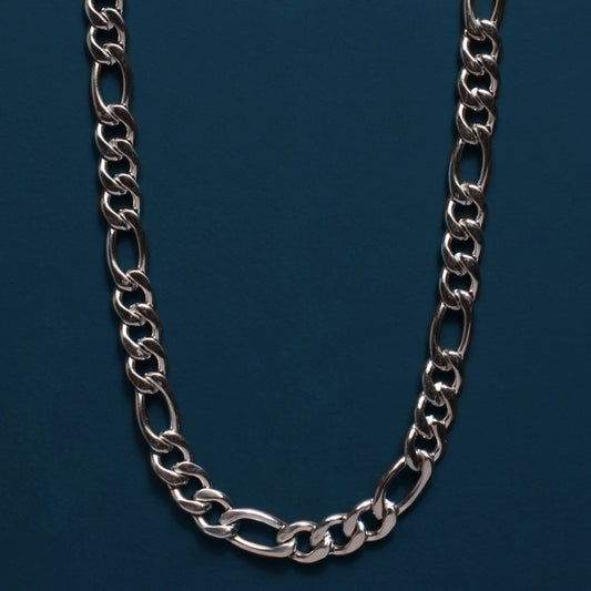 A silver-toned metal chain necklace with elongated oval links, arranged in a U-shape against a dark teal-blue background.