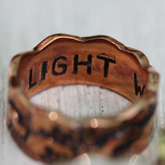 Silver ring with 'LIGHT' engraved on a white background