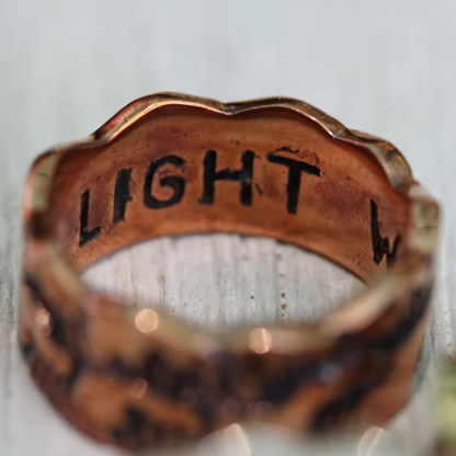 Silver ring with 'LIGHT' engraved on a white background