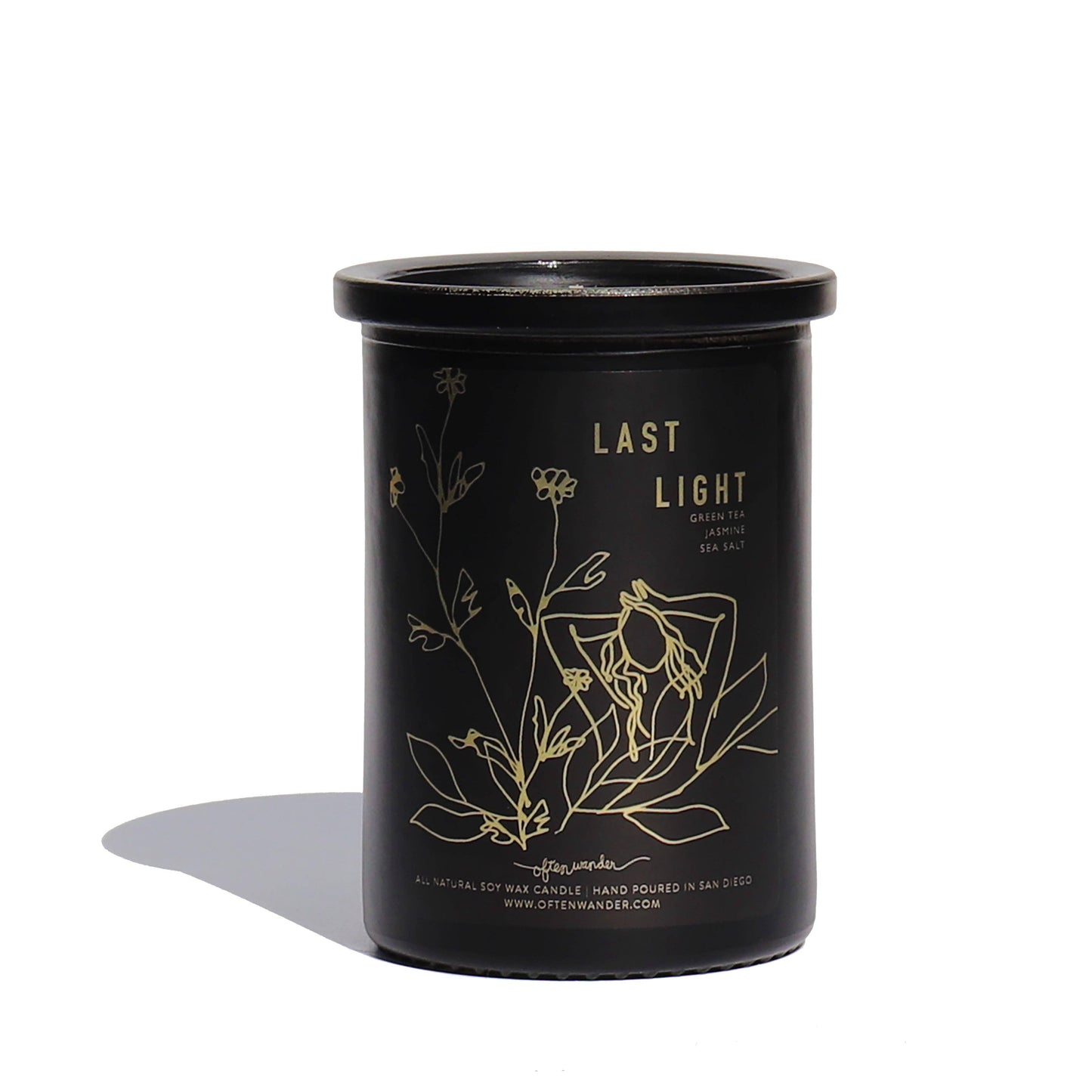 A black glass jar candle with a matching lid, featuring gold foil line art of flowers and the text 'LAST LIGHT' on the front, set against a plain white background with a soft shadow.