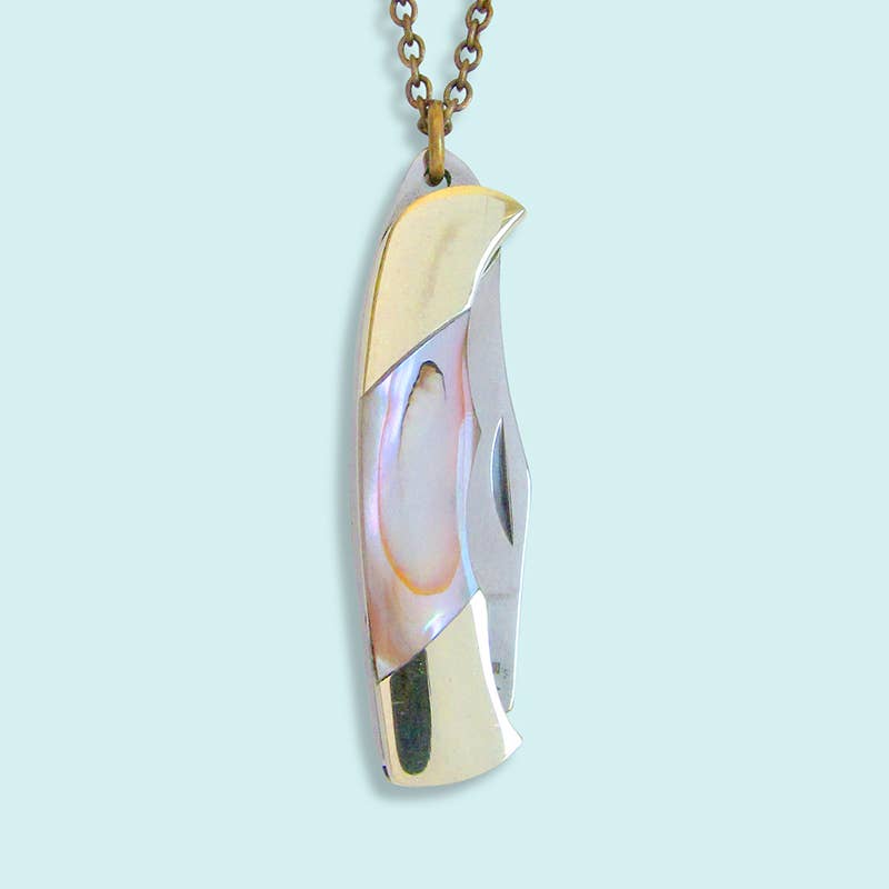 Gold and silver pendant on a light blue background