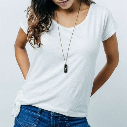Person wearing a white t-shirt and blue jeans with a plain background