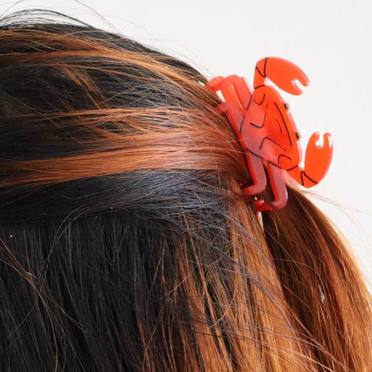 Red crab-shaped hair claw on a person's hair