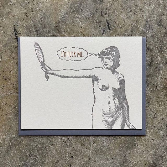 A square art print or card with a dark gray border, featuring a black-and-white illustration of a nude woman holding a mirror, with a speech bubble reading 'I'D FUCK ME'. The print is photographed flat on a textured gray surface.
