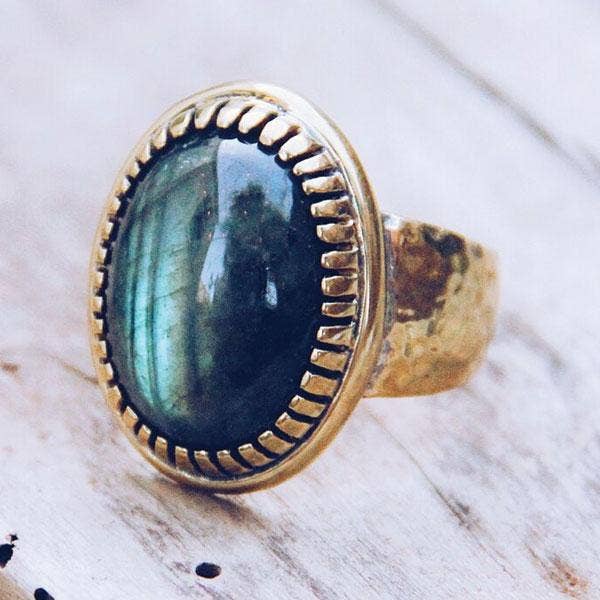 Silver ring with a blue green stone on a wooden surface