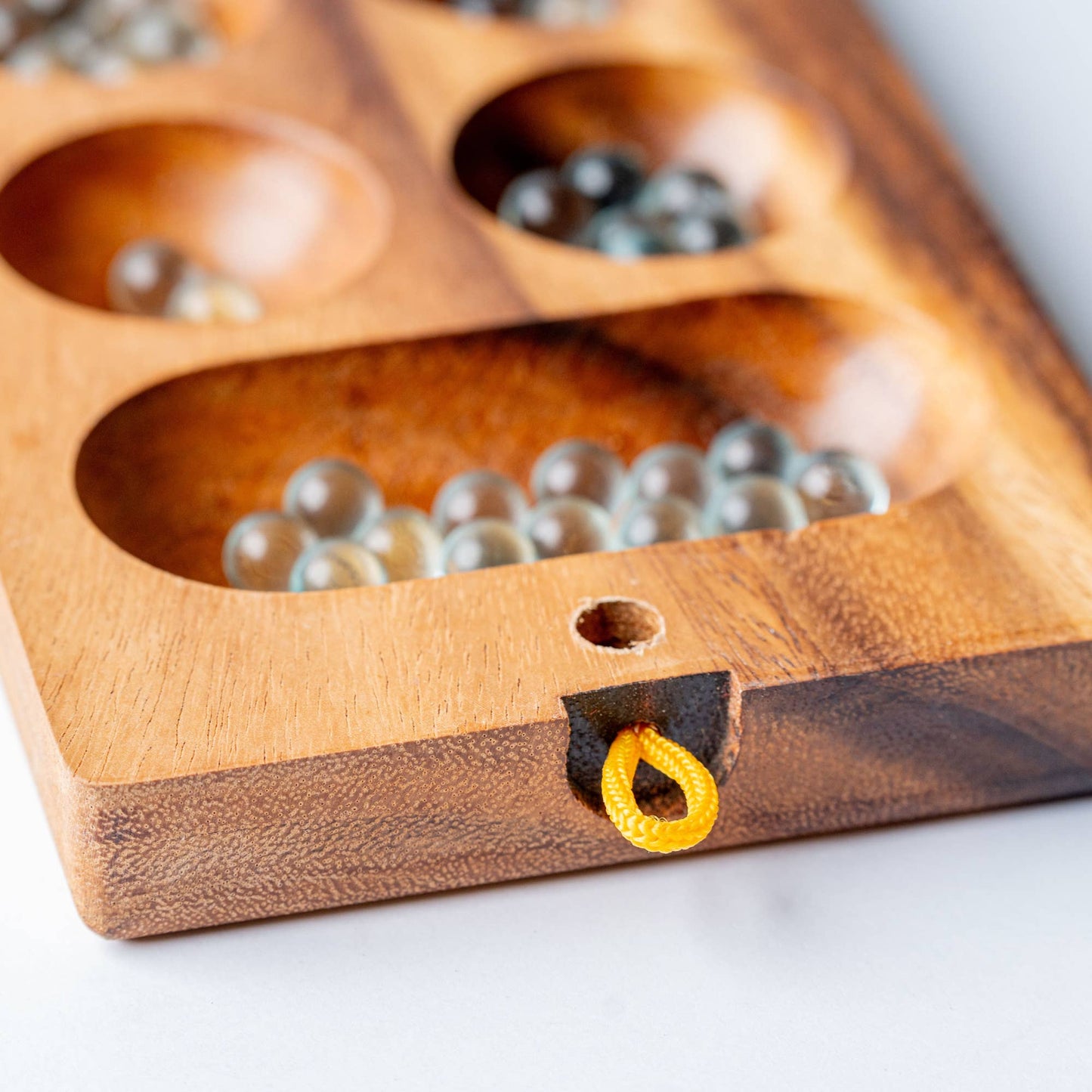 Wooden game board with beads on a white surface